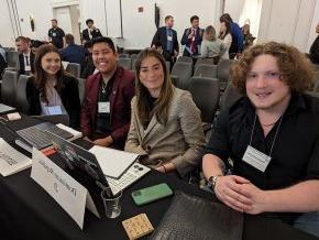 Four Model UN delegates sit behind a desk at the Southern Regional Model UN Conference